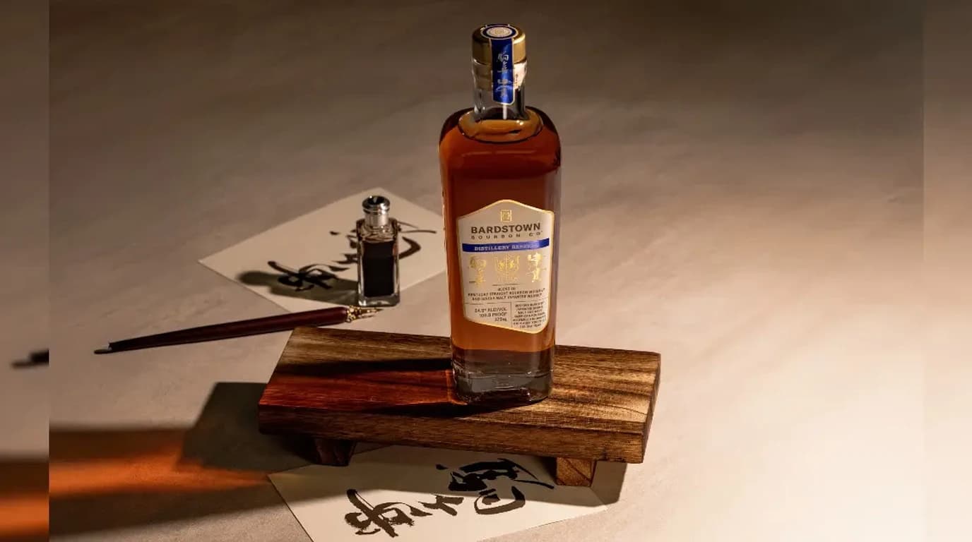 Bardstown Bourbon Company Distillery Reserve Mars bottle on a wooden display block with Japanese calligraphy paper, ink well, and brush in warm editorial lighting