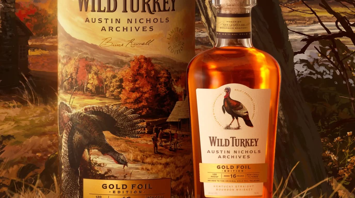 Wild Turkey Austin Nichols Archives Gold Foil Edition bottle and gift tube in an autumn rickhouse scene, labeled 16 years and 120 proof